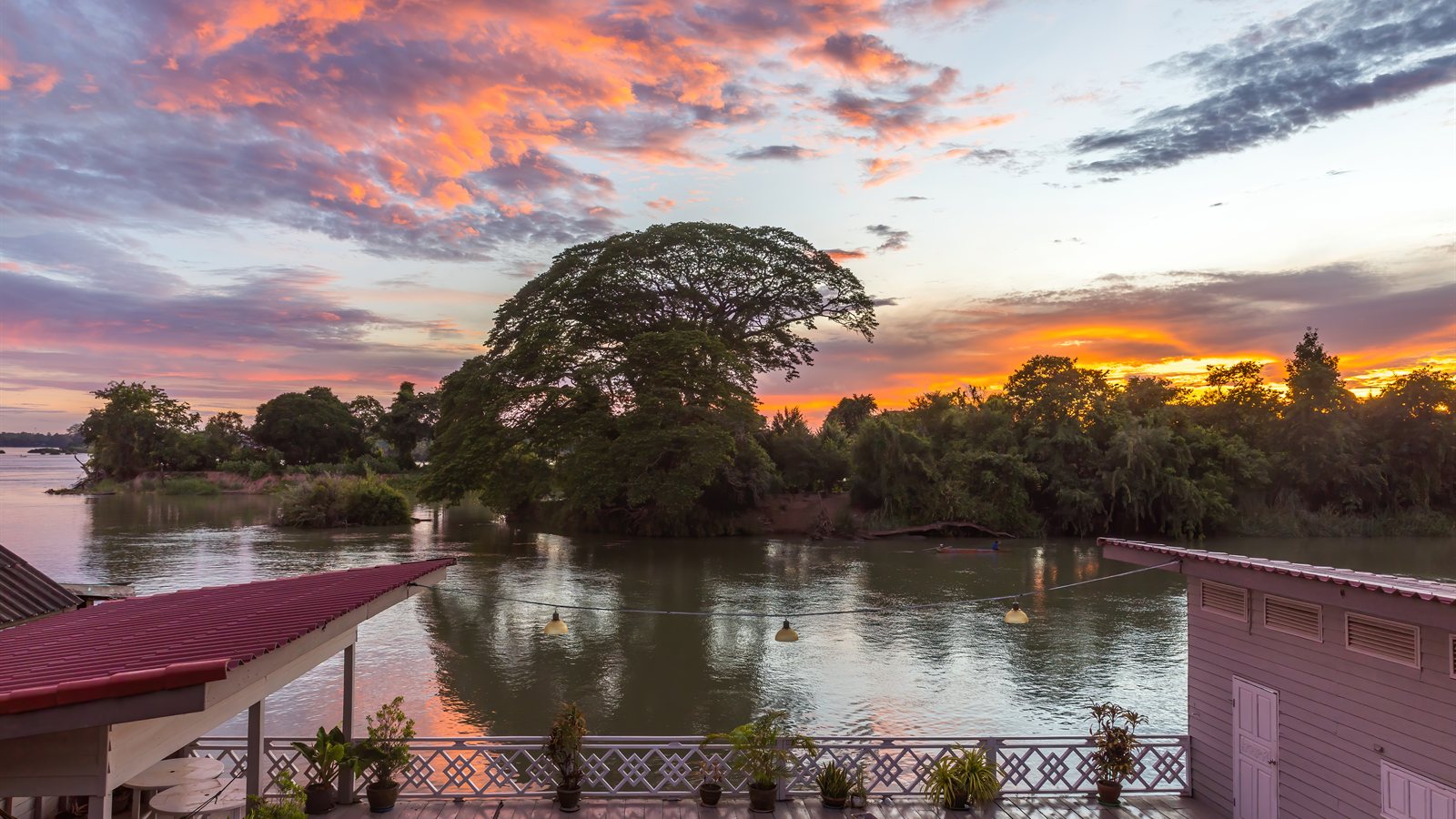 Riverside deck at dawn with coloured clouds above the water